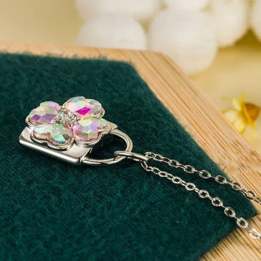 Halsband med glittrande hängsmycke i form av ett fyrklöverhänglås