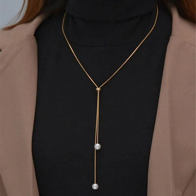 Lange Halskette mit Anhänger und goldenen Perlen